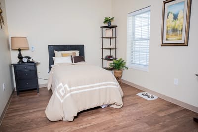 Cozy resident room featuring a bed and shelves