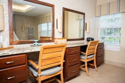 Brightly lit interior space with mirrors and wooden chairs