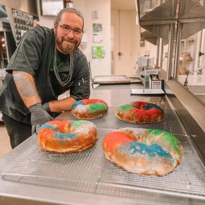 Chef with colorful king cakes in the kitchen