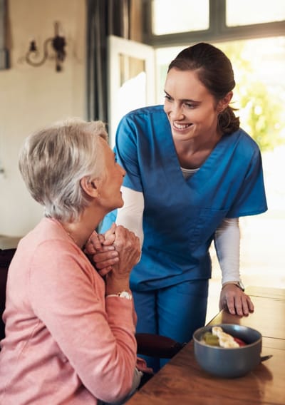 Caregiver interacting with resident over a meal
