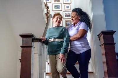 Caregiver assisting a resident on the stairs