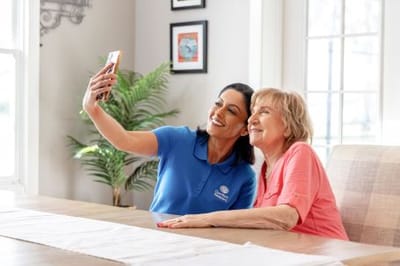 Caregiver and resident taking a selfie in a common area