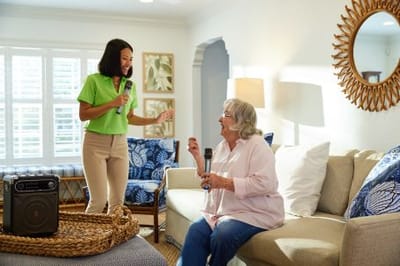 Staff member singing with a resident in a cozy activity room