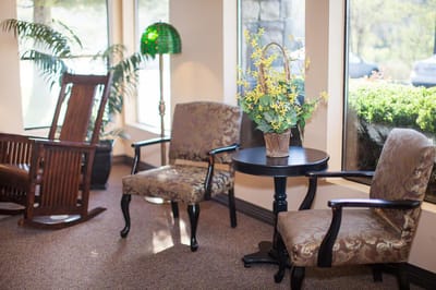 Well-furnished common area with rockers and plants