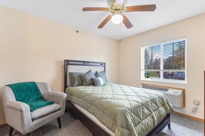 Cozy private bedroom with a green bedspread and window