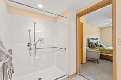 Accessible bathroom with grab bars and view into bedroom