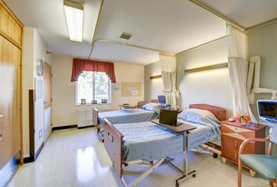 Shared resident room with two beds and medical equipment