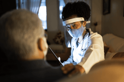 Healthcare professional assisting a senior resident indoors