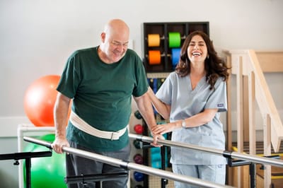 A nurse assisting a resident in a rehabilitation setting