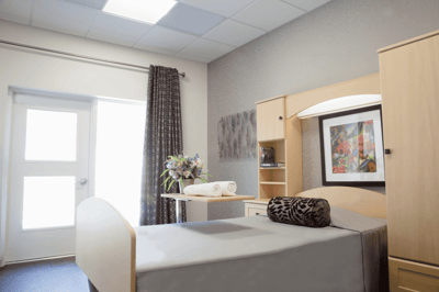 A well-furnished private resident room with a bed and flowers