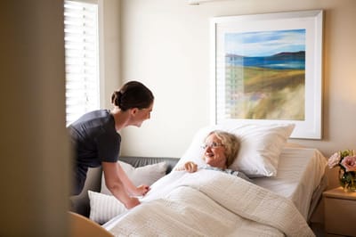 A caregiver assisting a resident in a cozy room