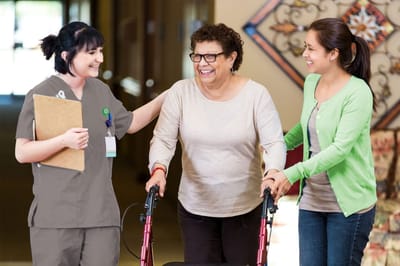 Staff assisting a resident in a hallway