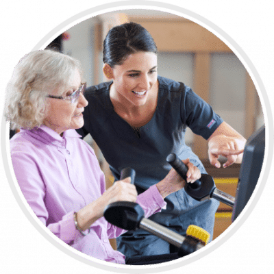 A caregiver assisting a resident with exercise equipment