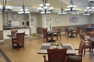 Dining room with tables and chairs set for residents