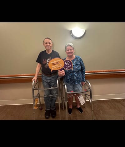 Two residents holding signs in an indoor setting