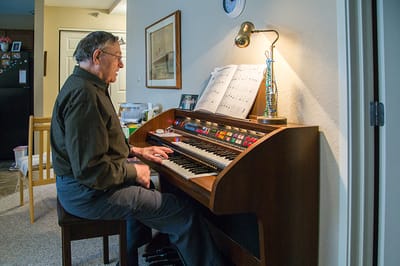 Resident playing the organ in a cozy room