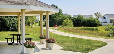 Scenic outdoor path near a gazebo with a walking resident