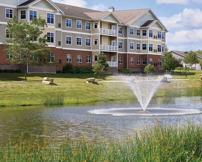 Exterior view of Luther Oaks with a pond and fountain