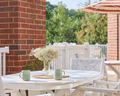 Outdoor seating area with flowers and coffee mugs