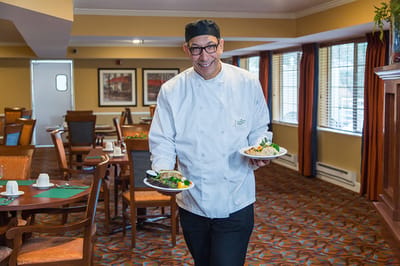 Staff member serving meals in the dining room