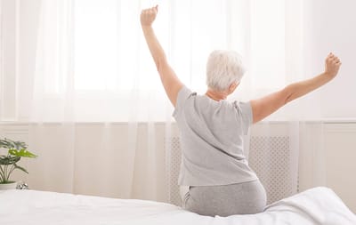 Senior resident stretching in a bright room