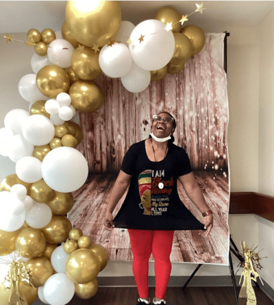A resident celebrates with balloons at an event