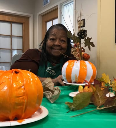 Resident decorating pumpkins during an activity