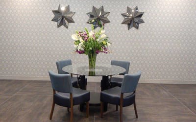 Bright common area with a circular table and flower arrangement