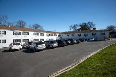 Exterior view of a nursing facility with parked cars