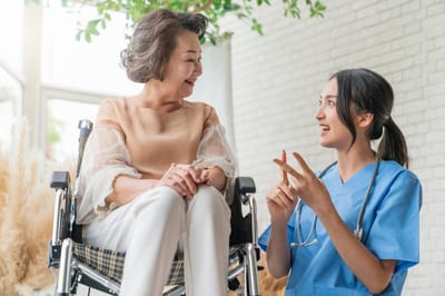 A caregiver and resident interacting happily in a bright common area