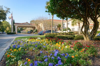 Exterior view of Life Care Center of Pensacola with flower beds