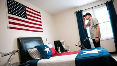 A resident saluting in a decorated room with flags