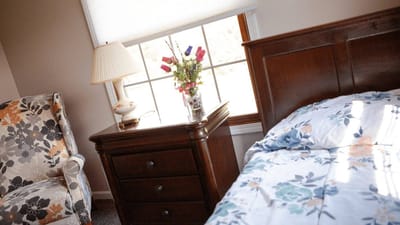 Cozy resident room with floral bedspread and lamp