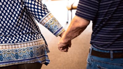 Two residents holding hands in a common area