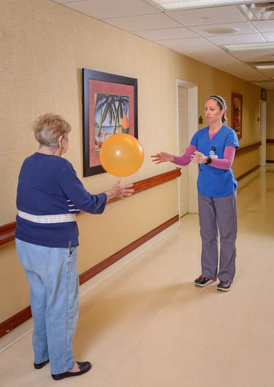 Staff engaging with a resident in a hallway activity