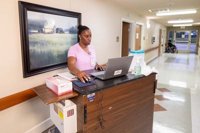 Staff member at a workstation in a facility hallway