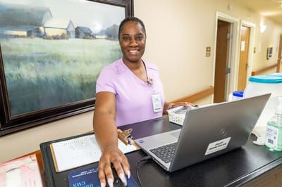 Staff member at a reception desk in a nursing facility