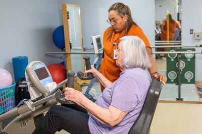 Resident engaging in exercise with staff assistance