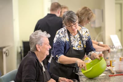 Staff member assisting a resident in a cooking activity