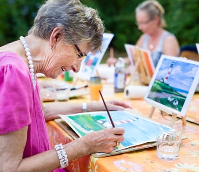 Seniors painting outdoors during an art activity