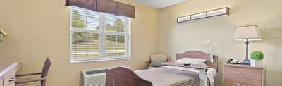 Cozy resident room with a bed and chair