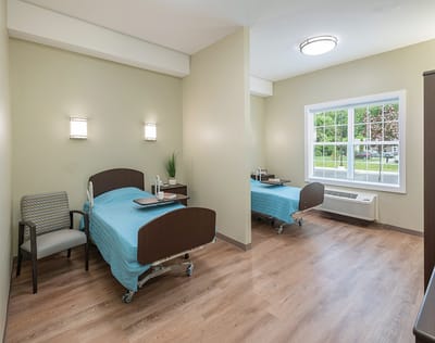 Bright private resident room with two beds and a window