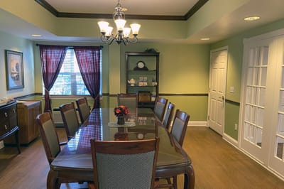 A dining room with a large table and chairs