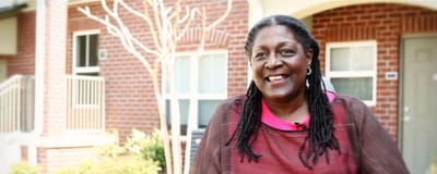 Resident smiling outside their apartment