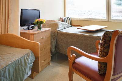 Cozy interior of a resident room with a bed and TV