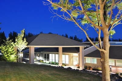 Exterior view of the facility at dusk with landscaping