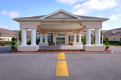 Front entrance of a senior living facility with landscaped gardens