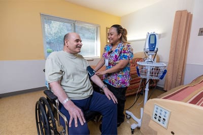 Resident receiving care from staff in a room