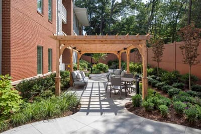 Outdoor seating area with shaded pergola and garden