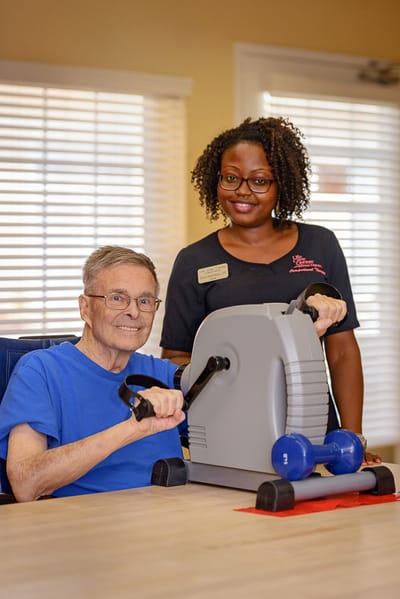 A resident exercising with assistance from staff